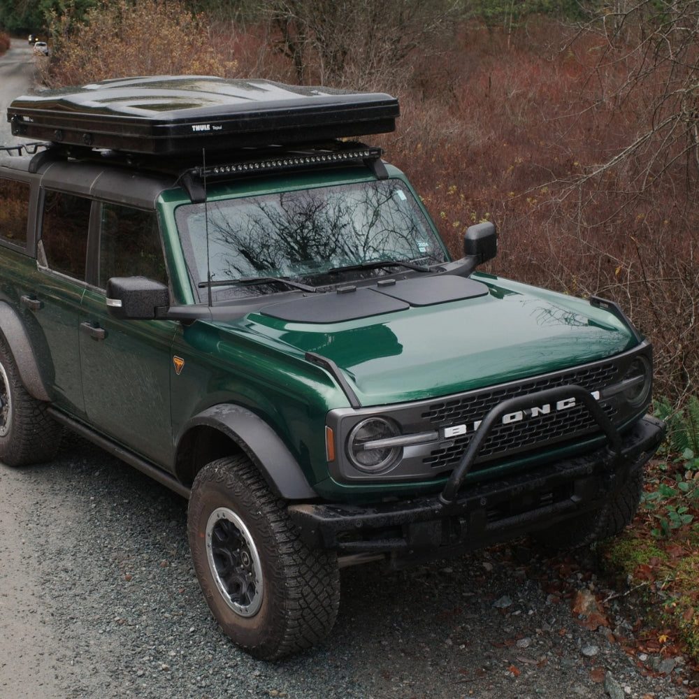 Ford Bronco with a Cascadia 4x4 solar panel on the hood at a camp site